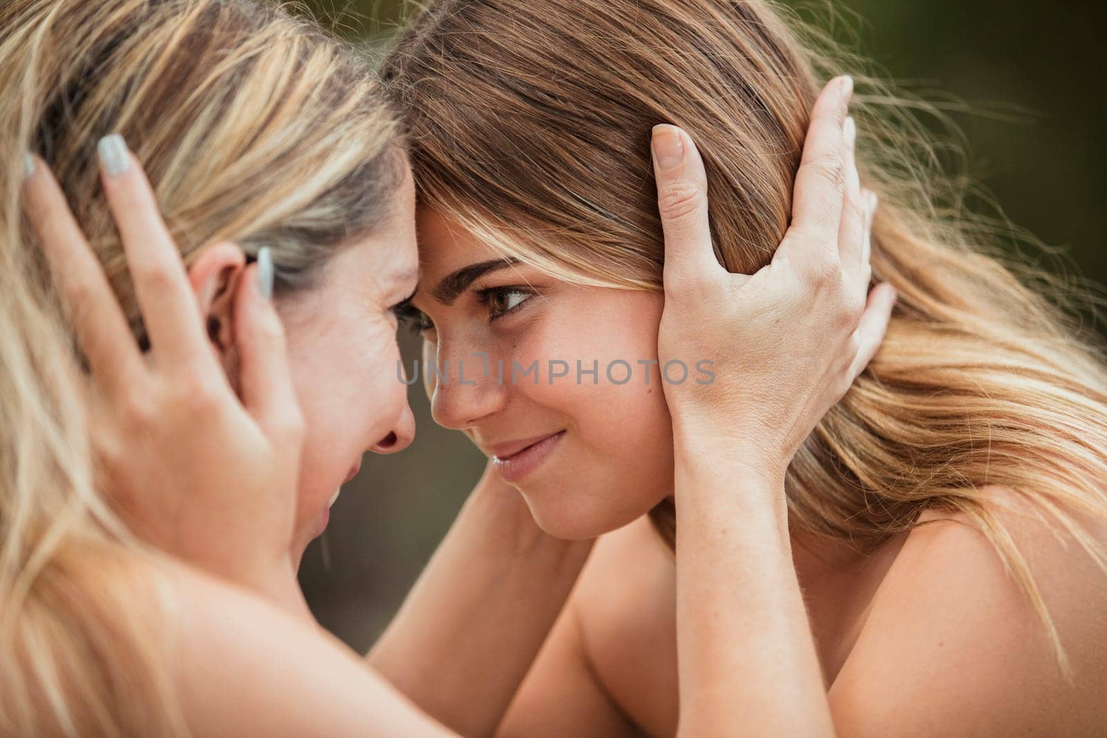 A mother and daughter are holding their heads and looking at each other.