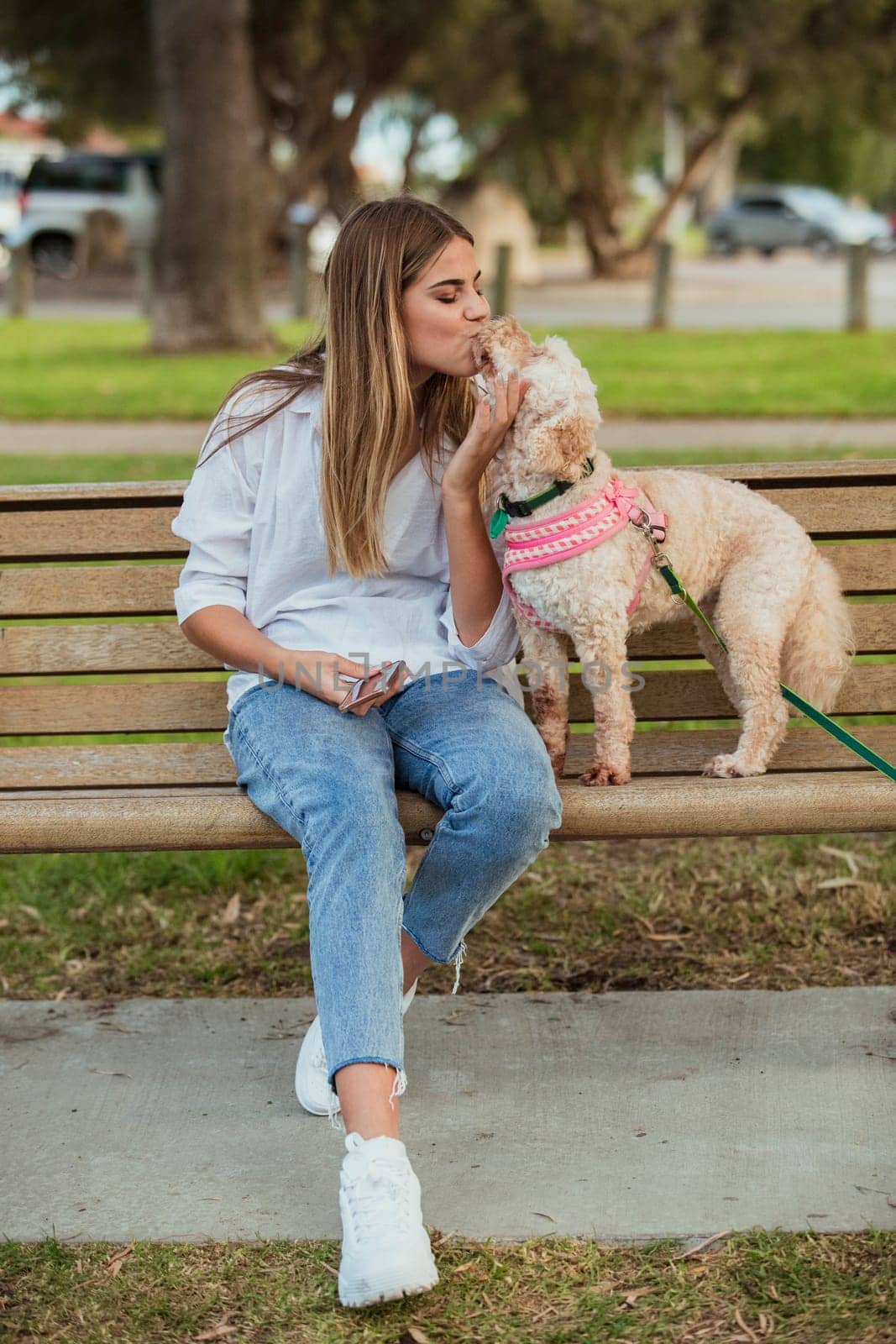 A teenage girl is being affectionate towards her dog.