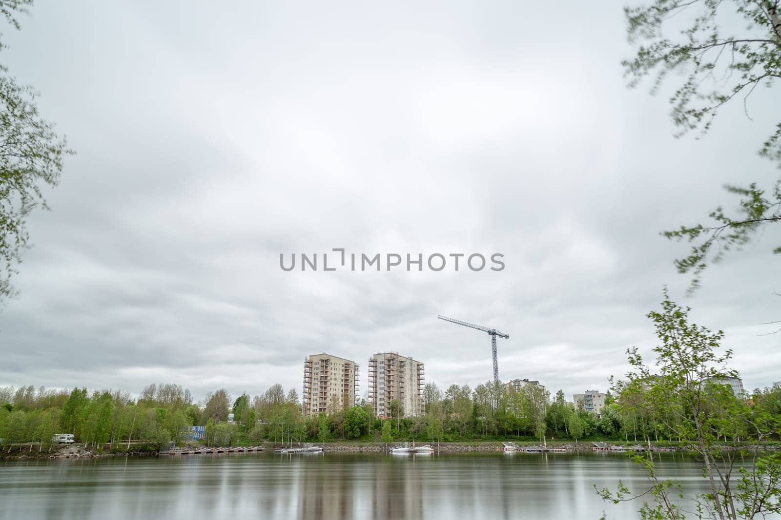 Appartment Buildings by River Under Construction with a cloudy sky.