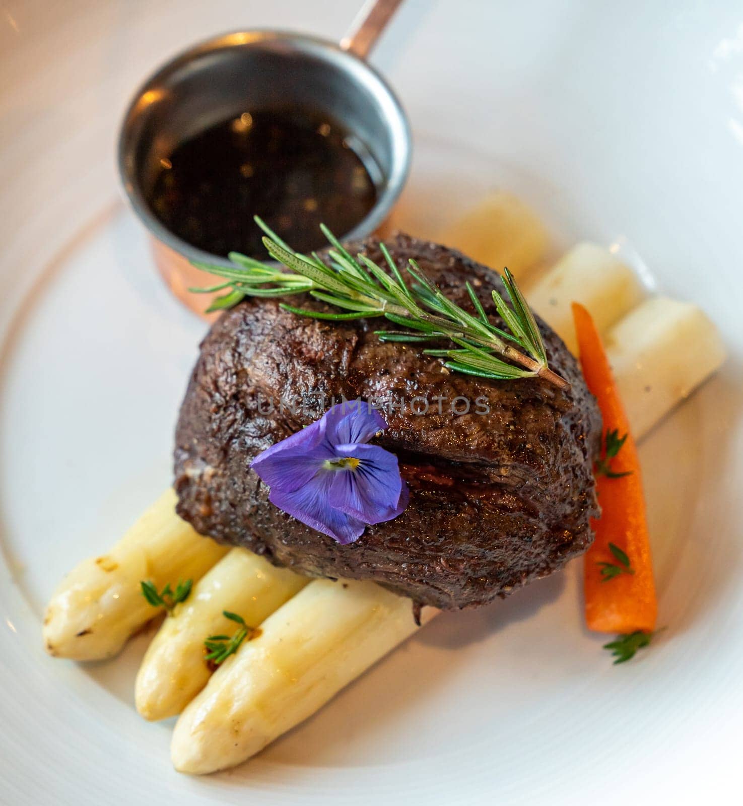 Grilled Beef Tenderloin wagyu with white asparagus decorate with edible flowers designed for square crop using.