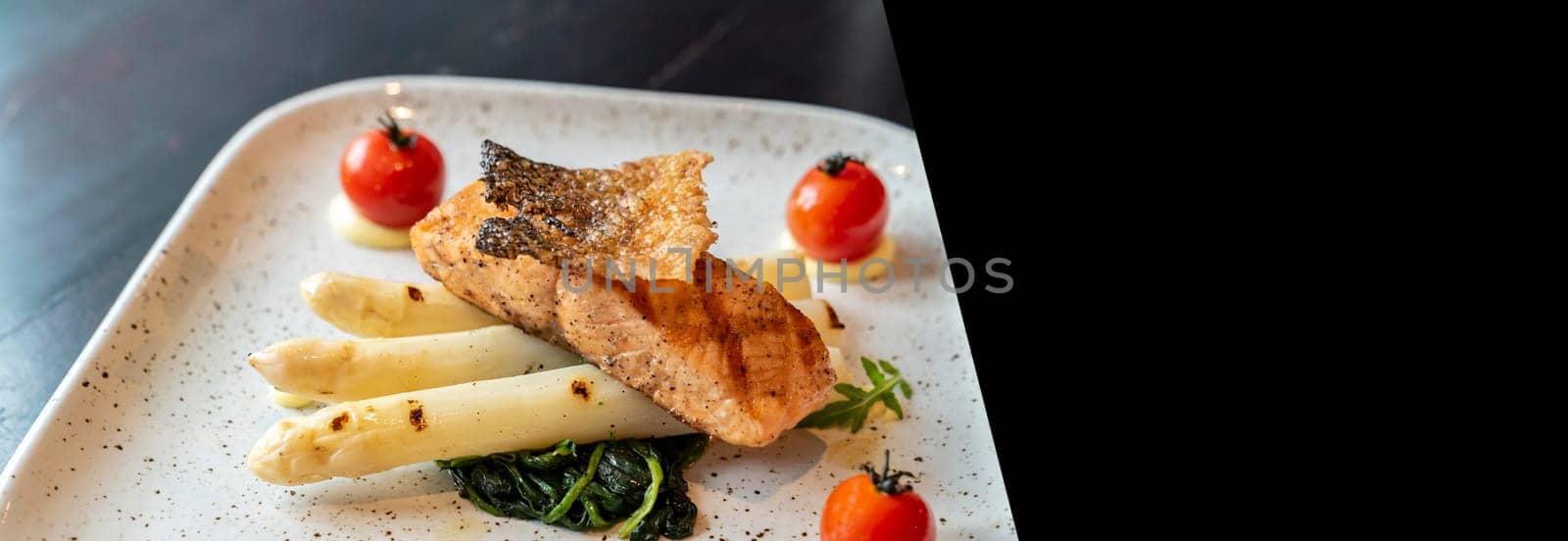 Grilled Salmon Fillet with grilled white asparagus serve with tomato and spinach designed for using as web banner