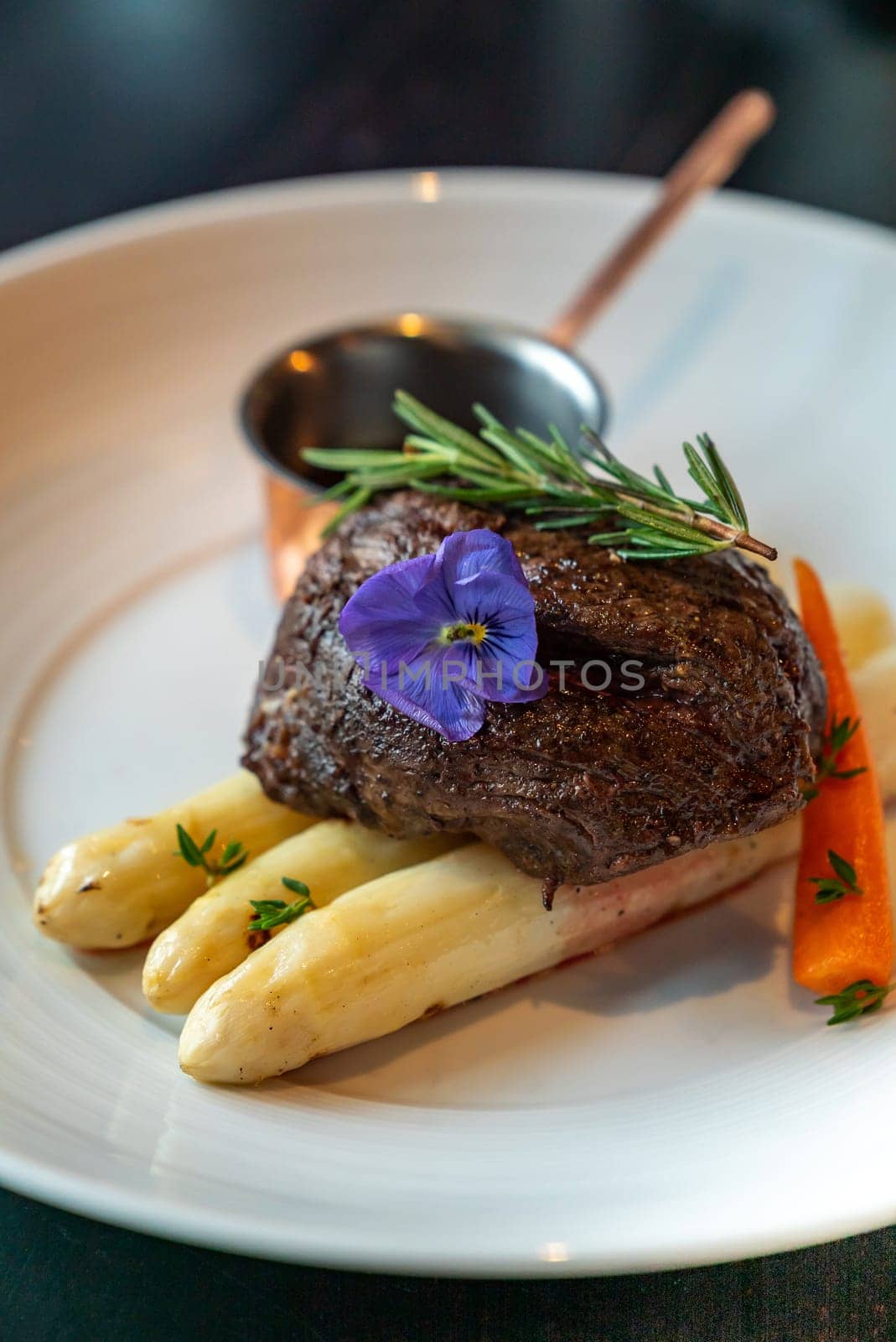 Grilled Beef Tenderloin wagyu with white asparagus decorate with edible flowers