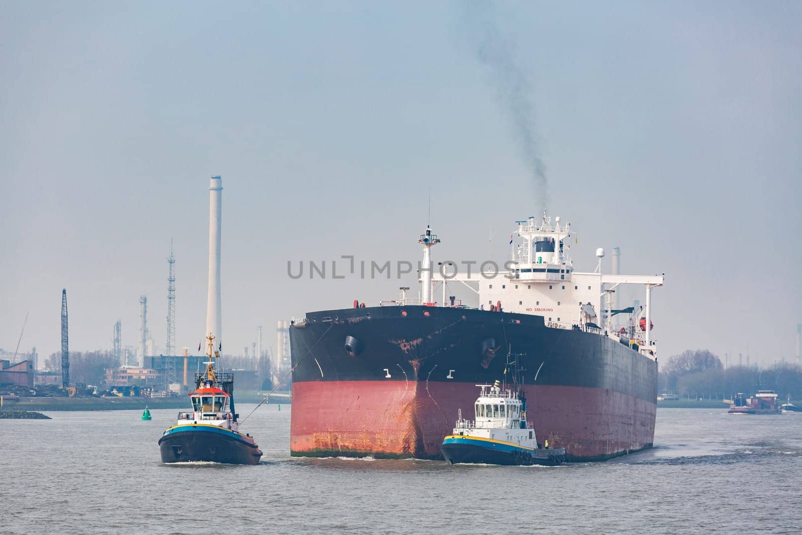 Big Cargo Containers Boat with Goods cargo Stack at the Pier docks port waiting for international sea freight transportation in Rotterdam Port of Netherlands