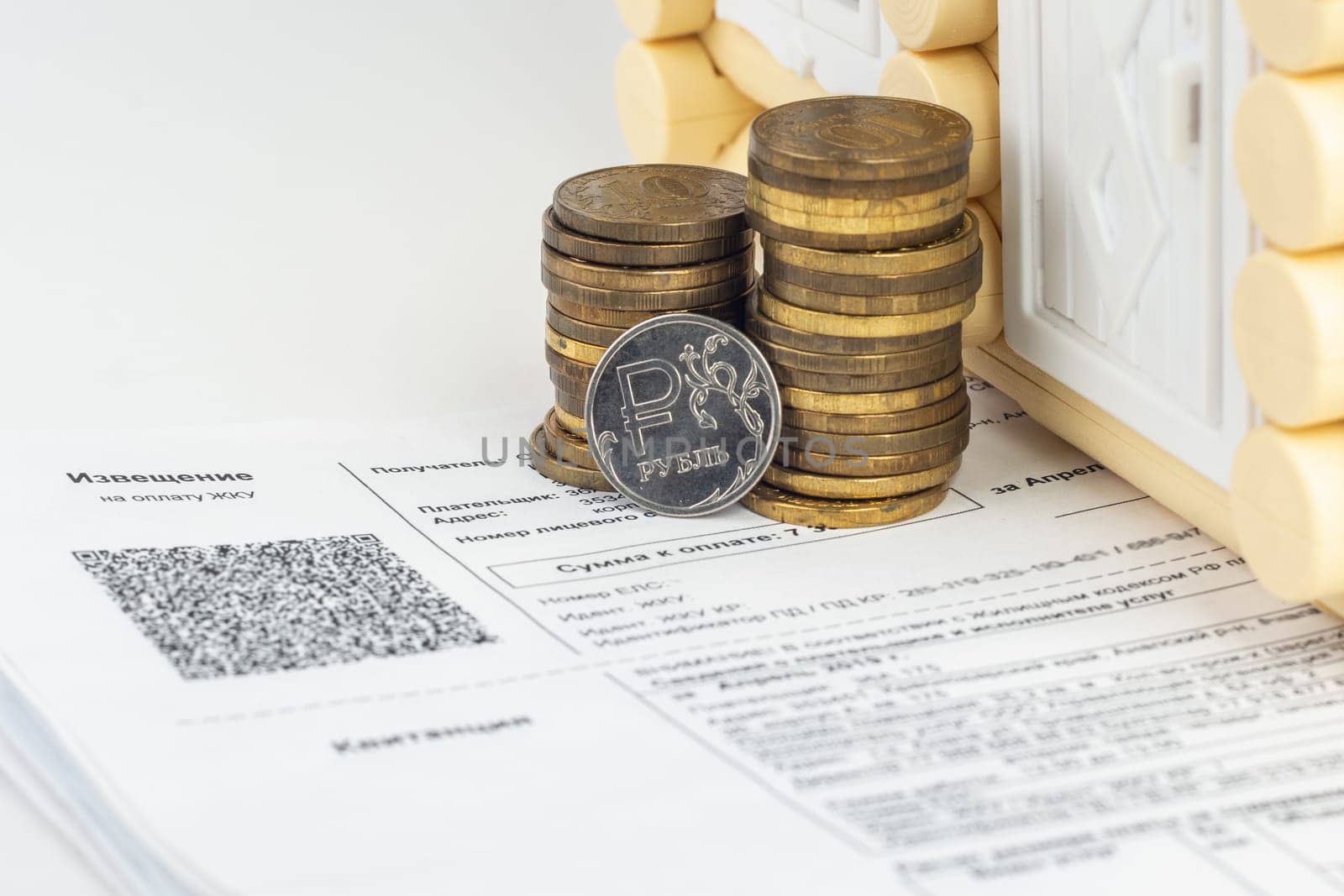A stack of money and one ruble coin in the bills for an apartment
