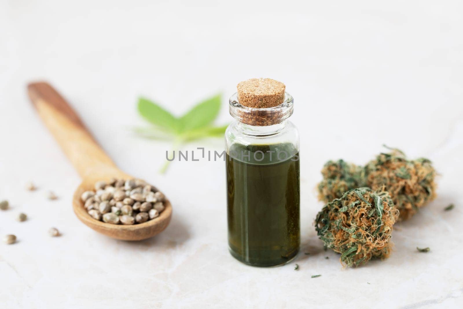 Cannabis oil in small bottle with cannabis bud and seeds
