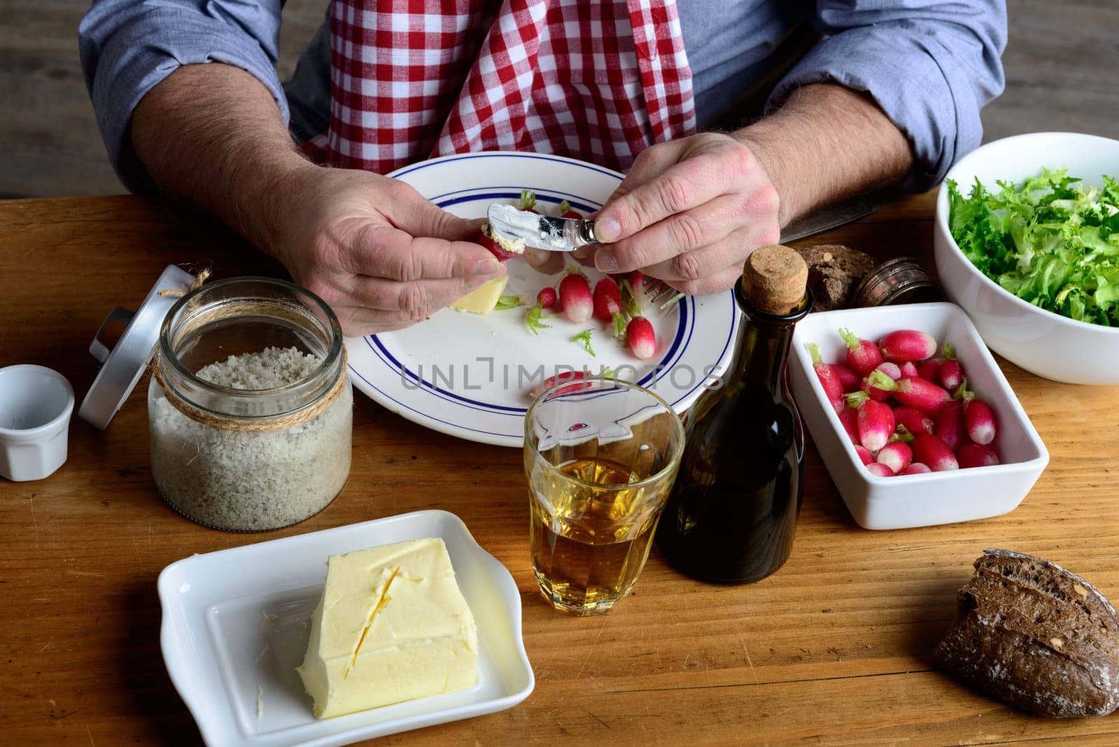 man with a checkered towel eat radishes with butter