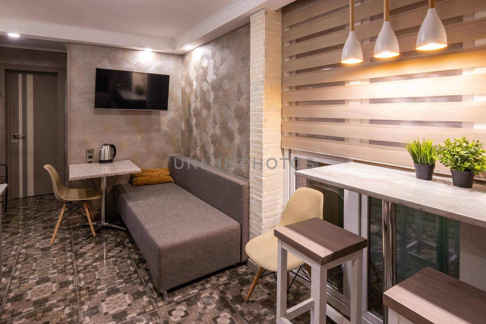 The interior of a small living room in the hotel room, combined with kitchen