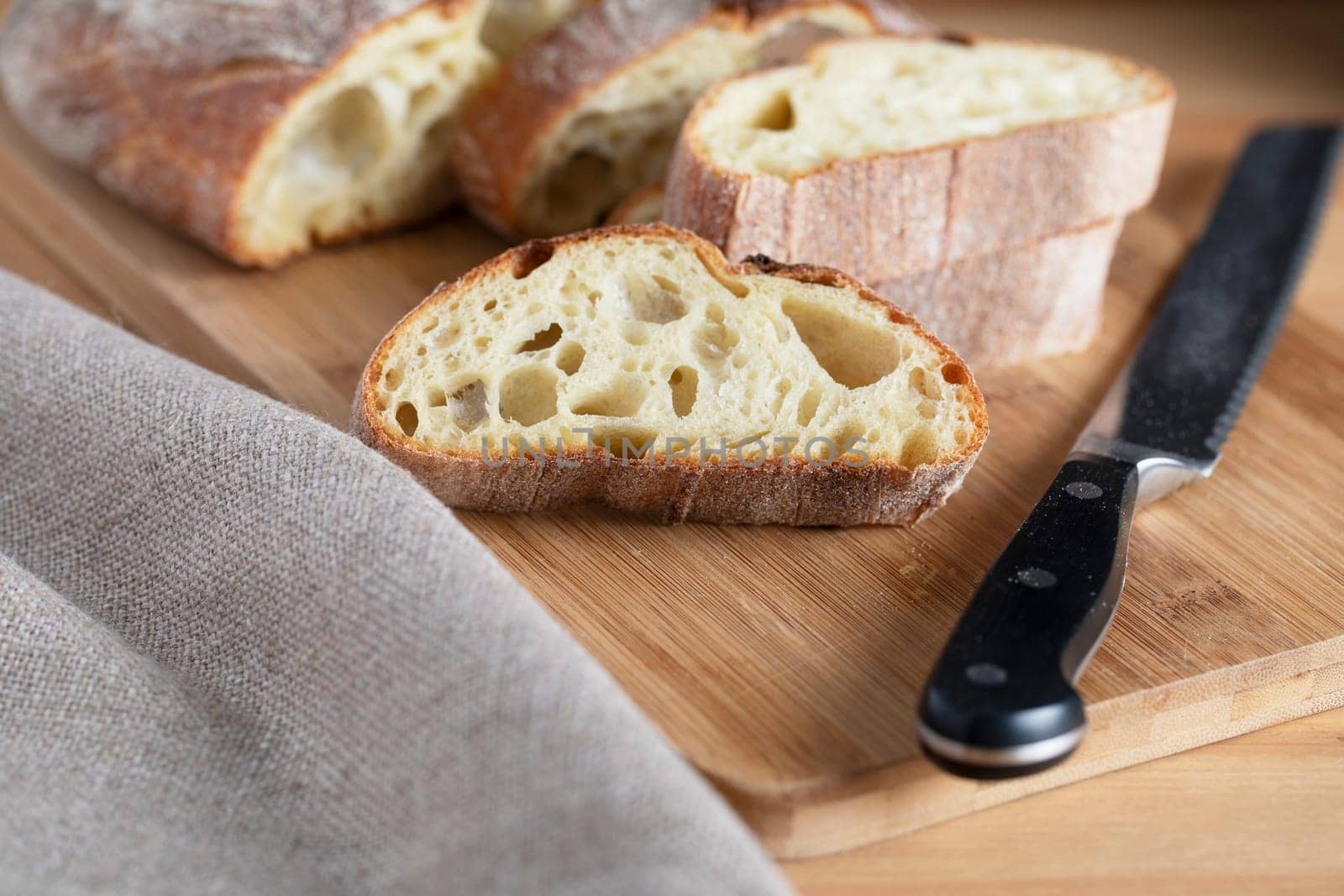 Slice of rustic bread on cutting board with knife