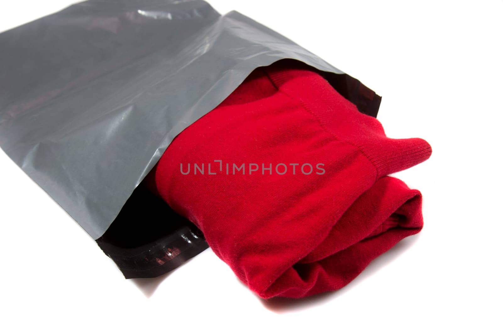 red jumper packed in gray mailing bag