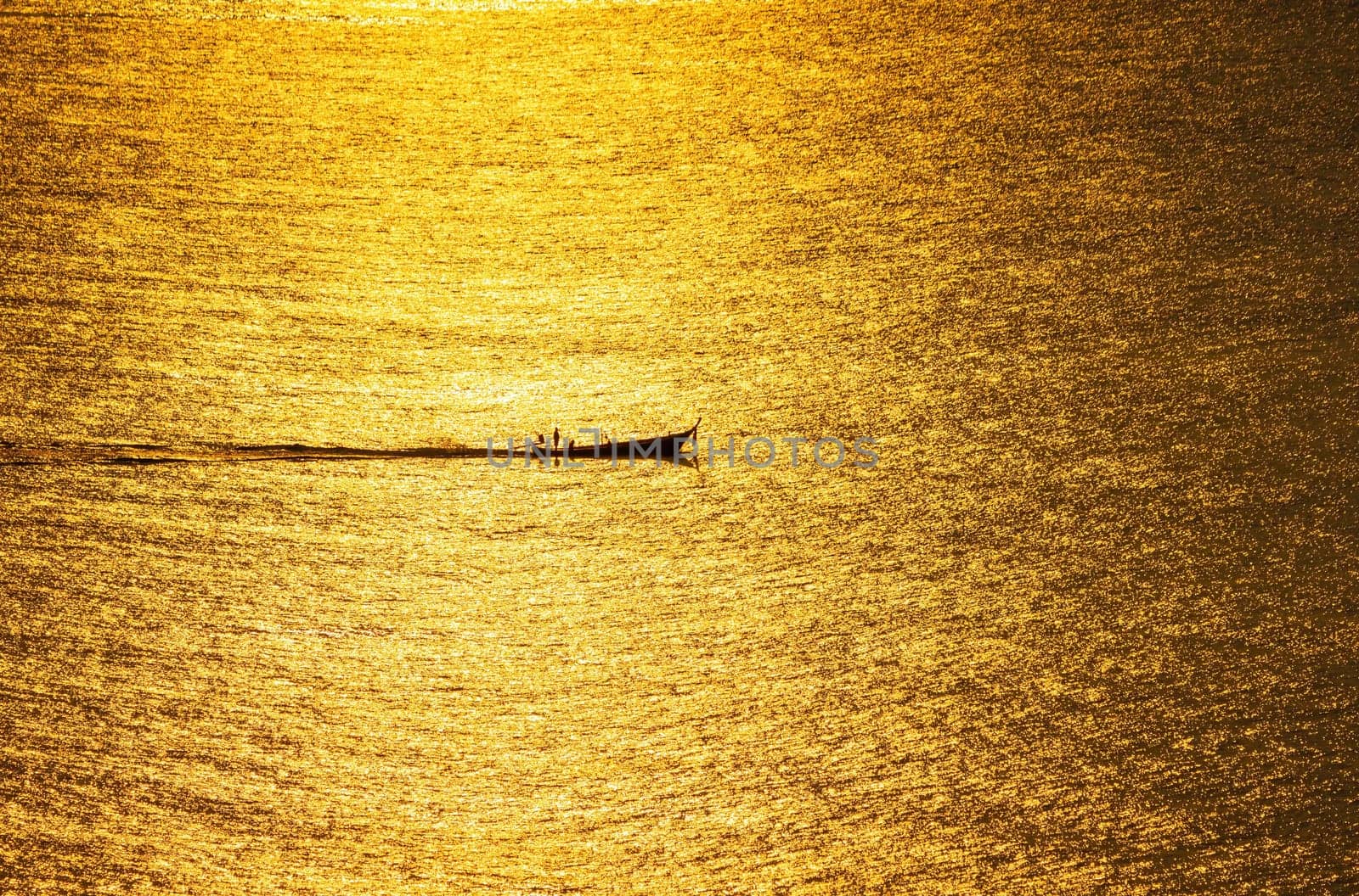 The sunset, the sea surface reflects the sunlight in gold. The ship ran through the sparkling sea surface.