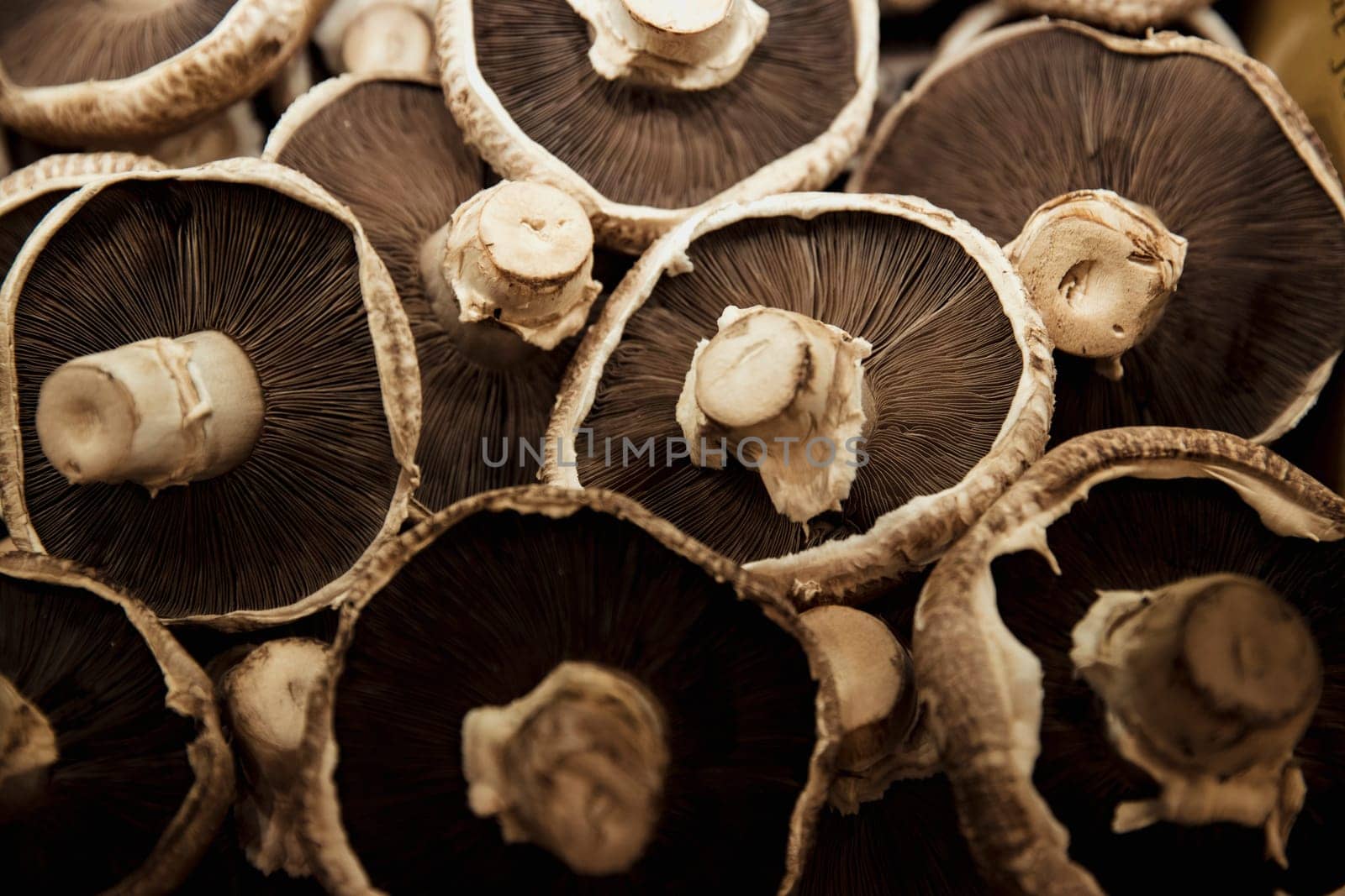 A close-up shot of an abundance of fresh Mushrooms on display at a market stall.