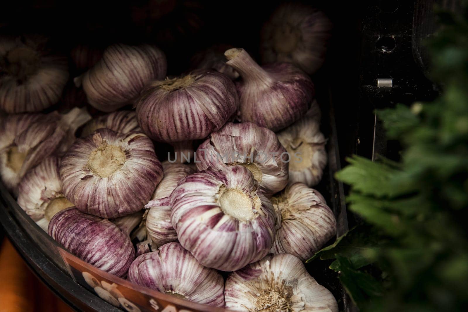 A close-up shot of an abundance of fresh garlic bulbs on display at a market stall.