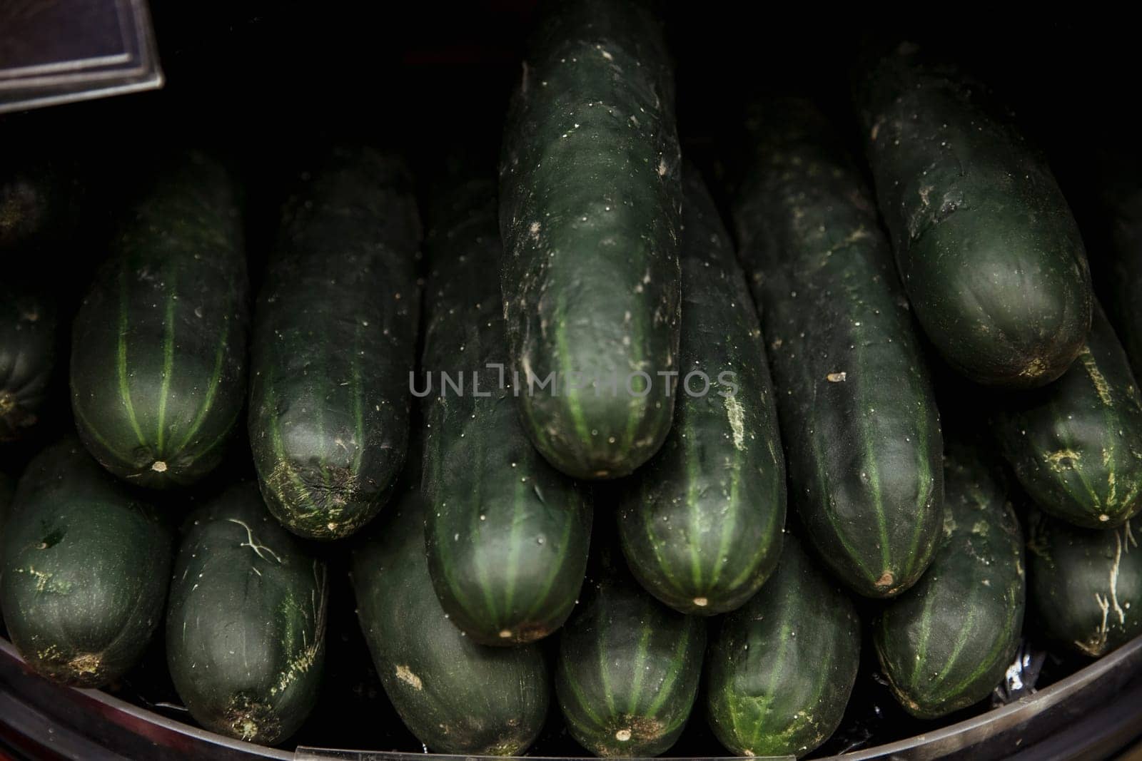 A close-up shot of an abundance of fresh courgette's on display at a market stall.