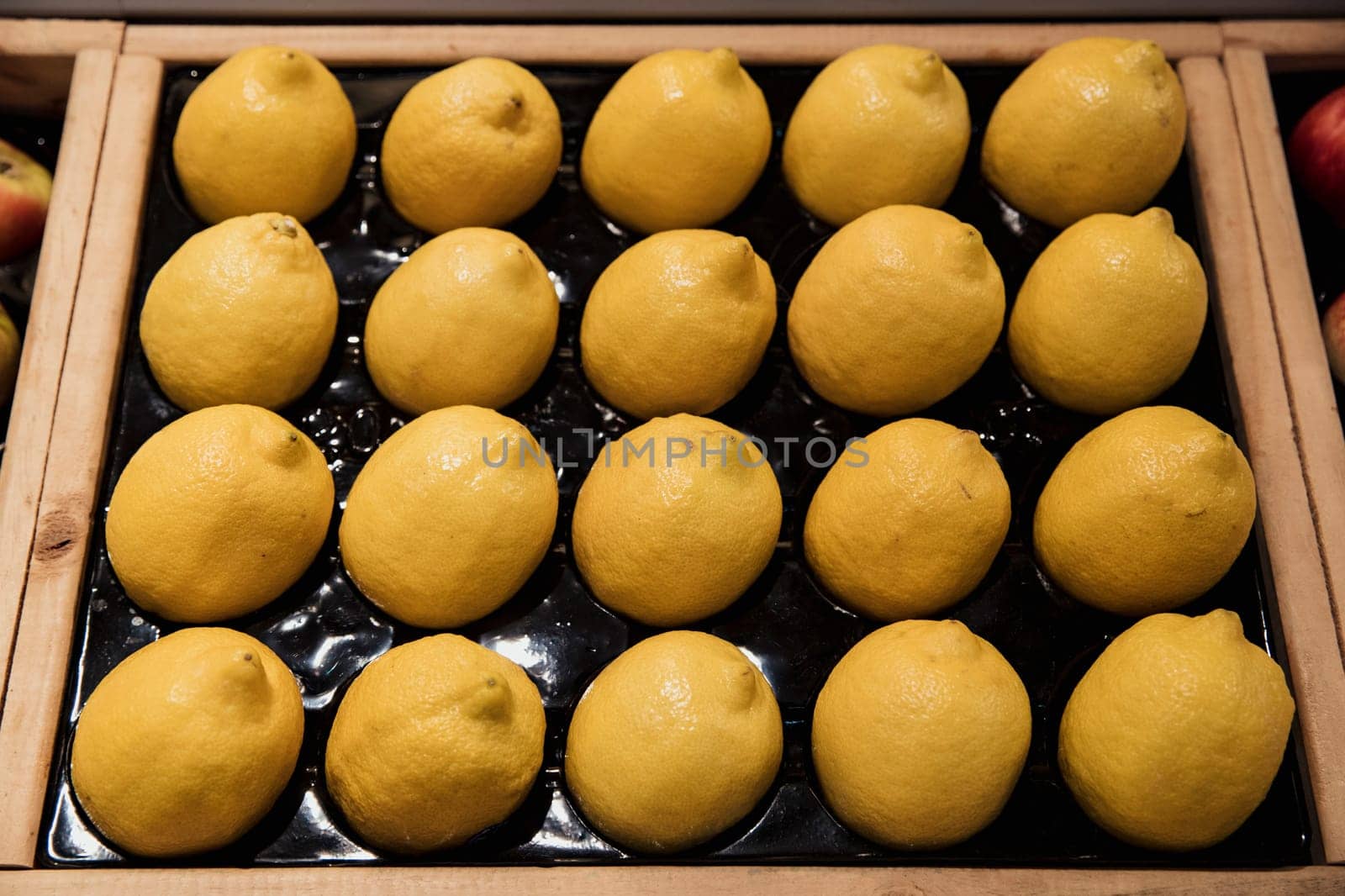 A close-up shot of an abundance of fresh Lemons on display at a market stall.