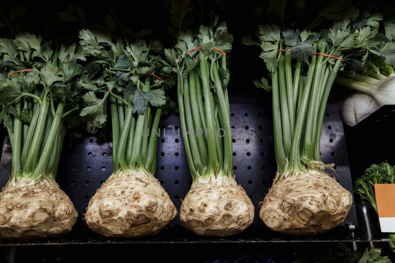 A close-up shot of an abundance of fresh celery on display at a market stall.