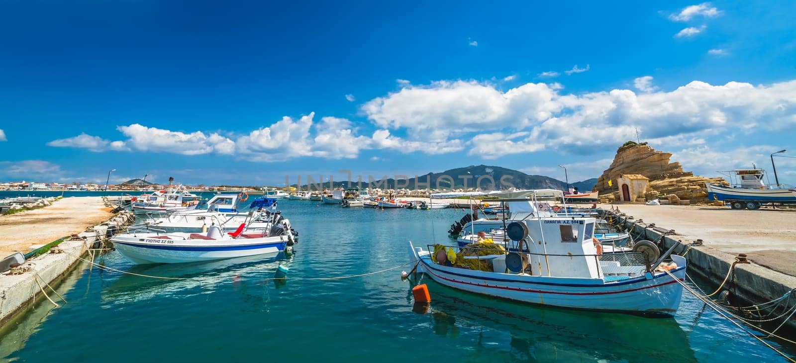 Zakynthos, Greece -  April 2019 : Small fishermen boats and speed and fast private motorboats moored in the Laganas port