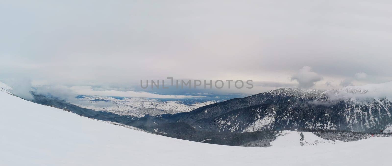 Beautiful view from the top of Pirin mountains, snowy winter morning above the clouds, Bankso, Bulgaria.