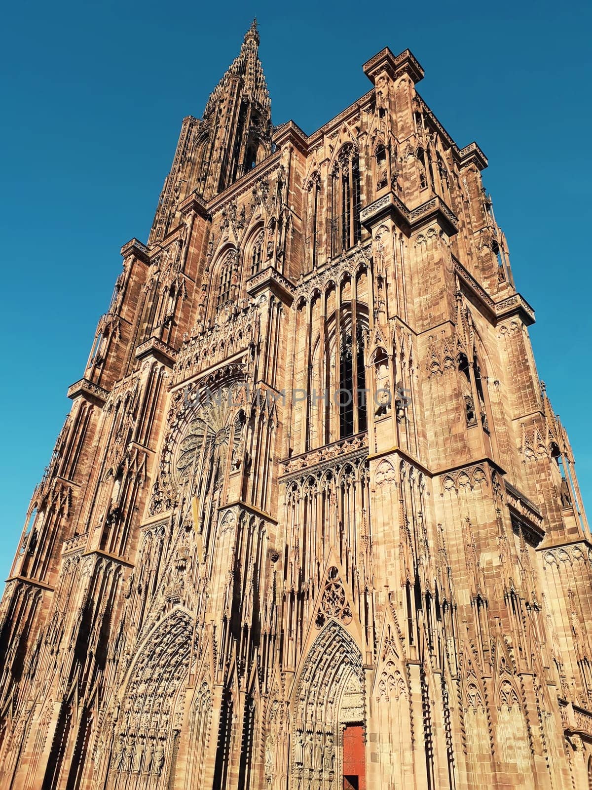 Main entrance of Roman Catholic Cathedral Notre Dame of Strasbourg in Alsace, France. Beautiful sunny day with clear blue sky. Majestic gothic architecture.