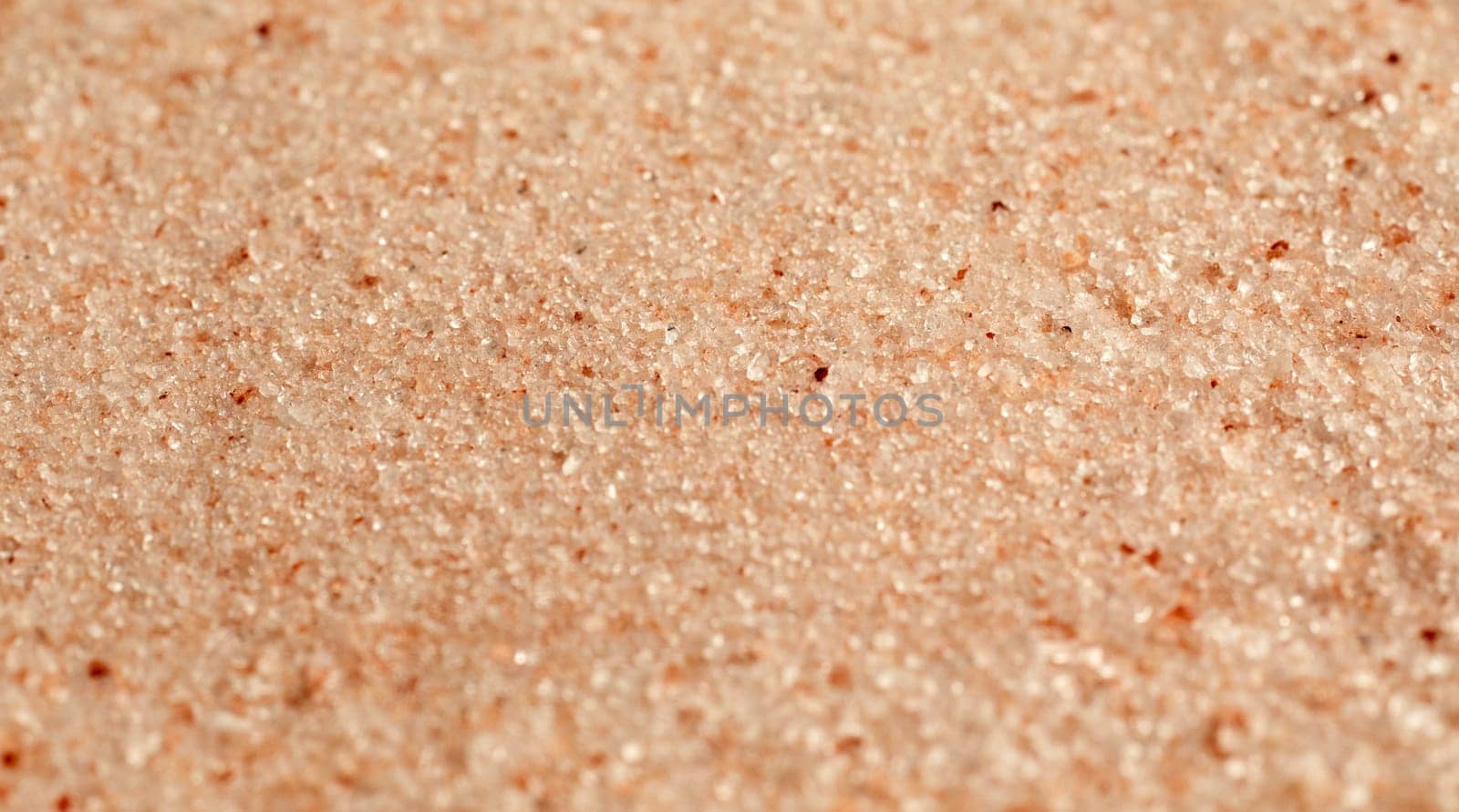 Background texture of fine ground red Pakistani hill salt colored naturally with iron oxide in a full frame panorama banner