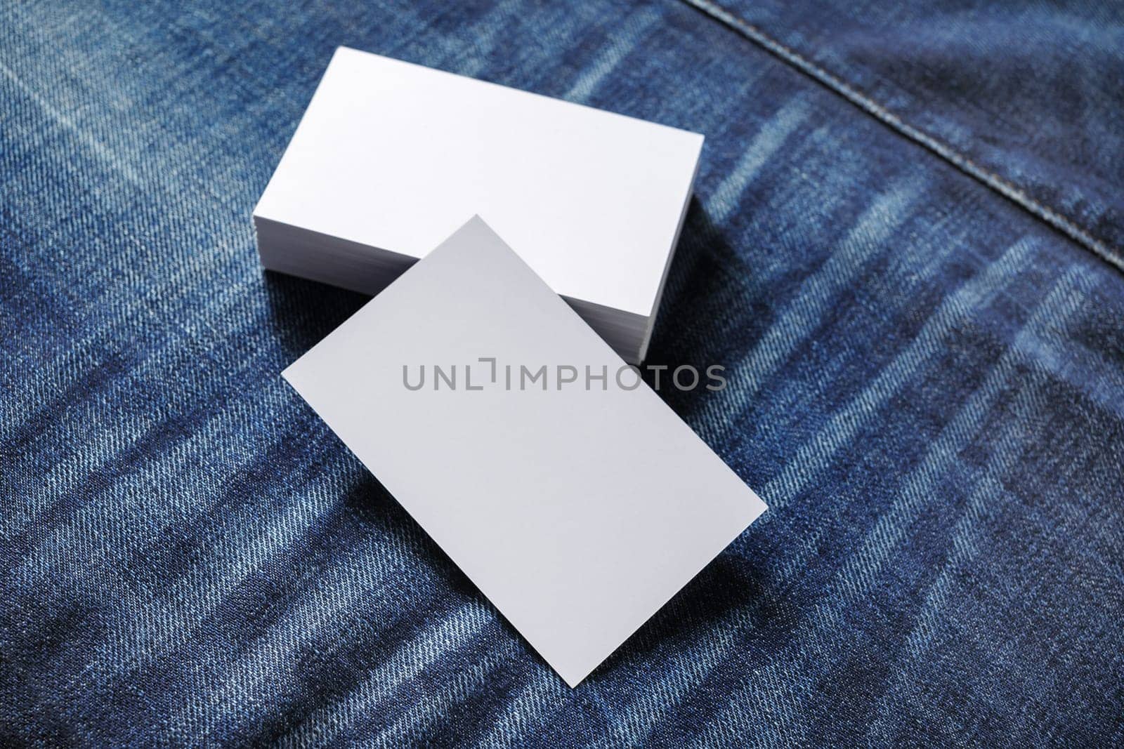 Blank business cards on denim background. Template for branding identity. Mockup for ID. Selective focus.