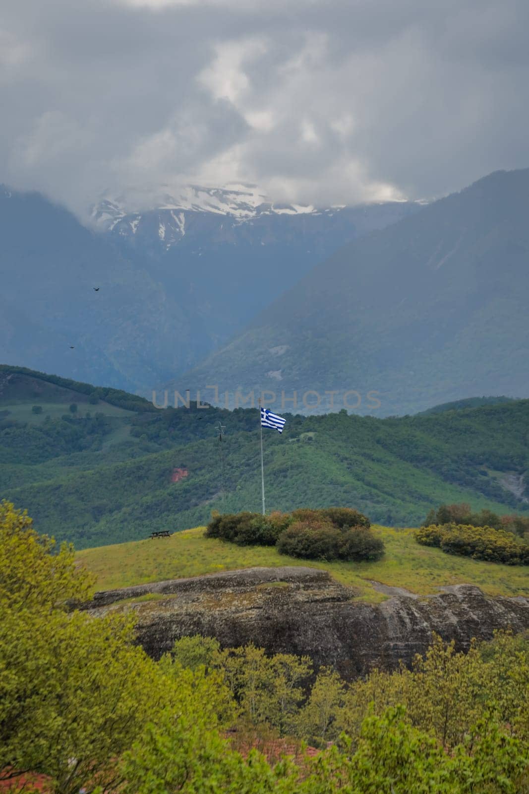 Greek flag on a tall mast pole on the hill in Kastraki village in Meteora, northern Greece