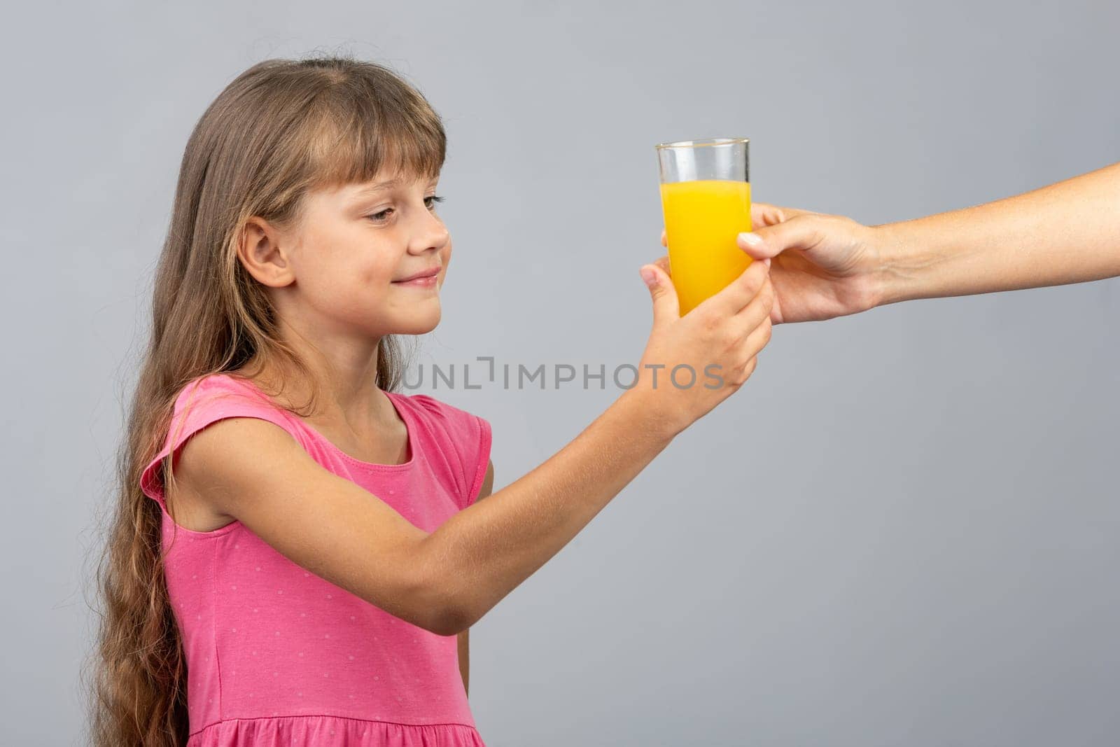 The girl takes from her hand a glass of orange juice