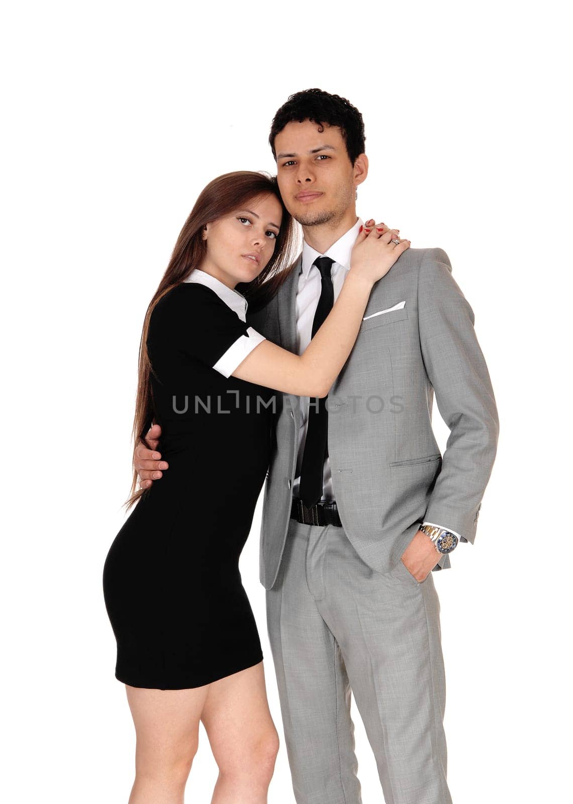 A beautiful young couple standing in a gray suit and black dress in a .loving pose, isolated for white background.