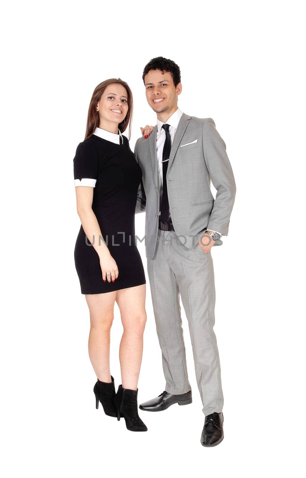 A happy young couple in suit and dress standing smiling isolated for.white background.