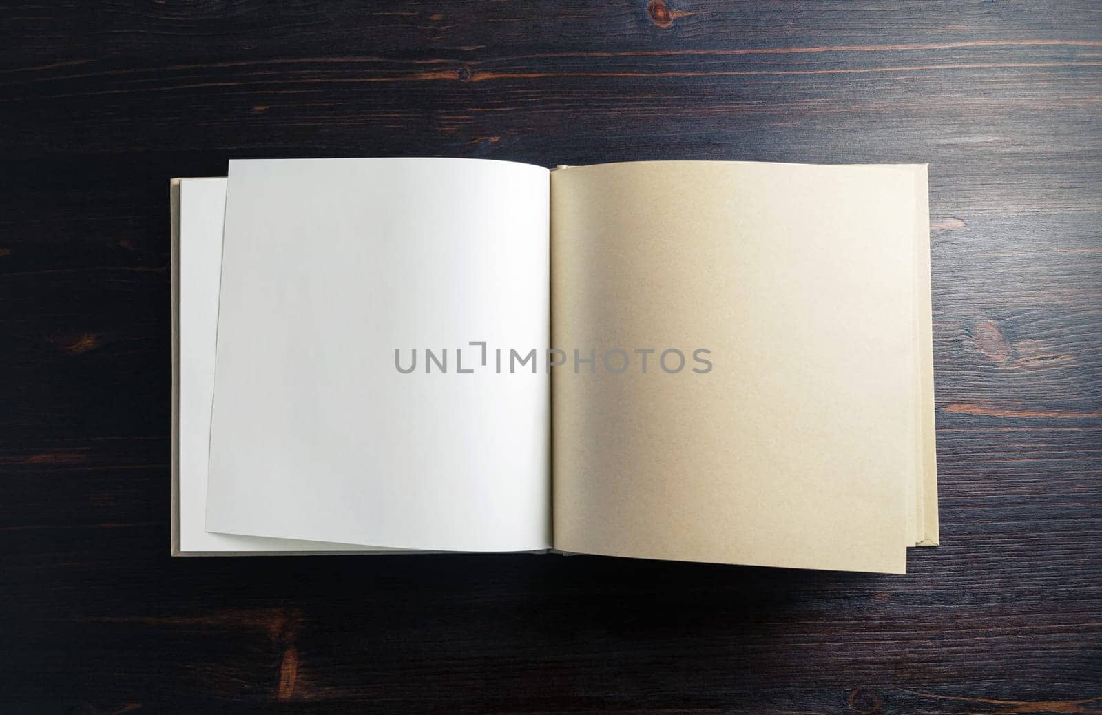 Blank notepad or sketchbook on dark wood table background. Copy space for text. Flat lay.
