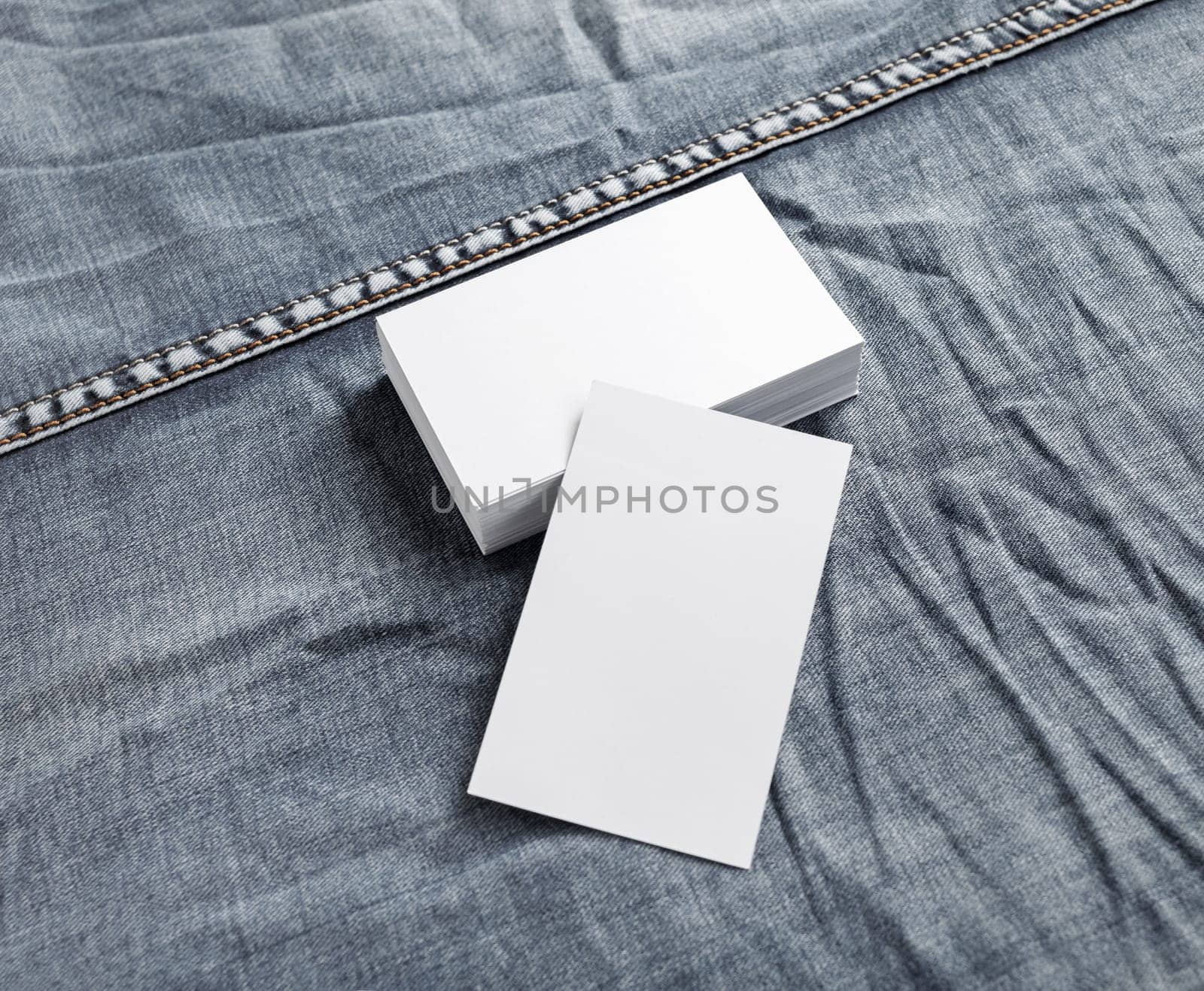 Blank white name cards on denim background. ID mock up.