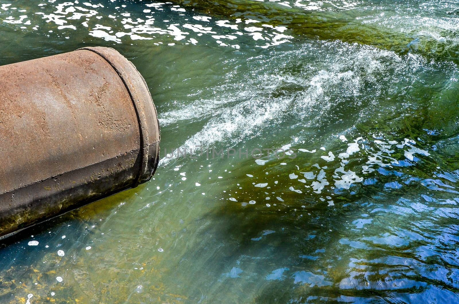 Water flows from the pipe into the river