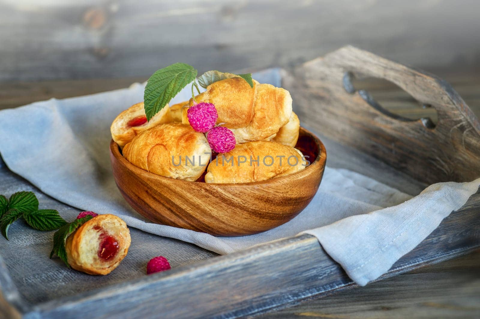 Croissants, a cup with kefir and ears of grain on a wooden tray. The concept of a wholesome breakfast