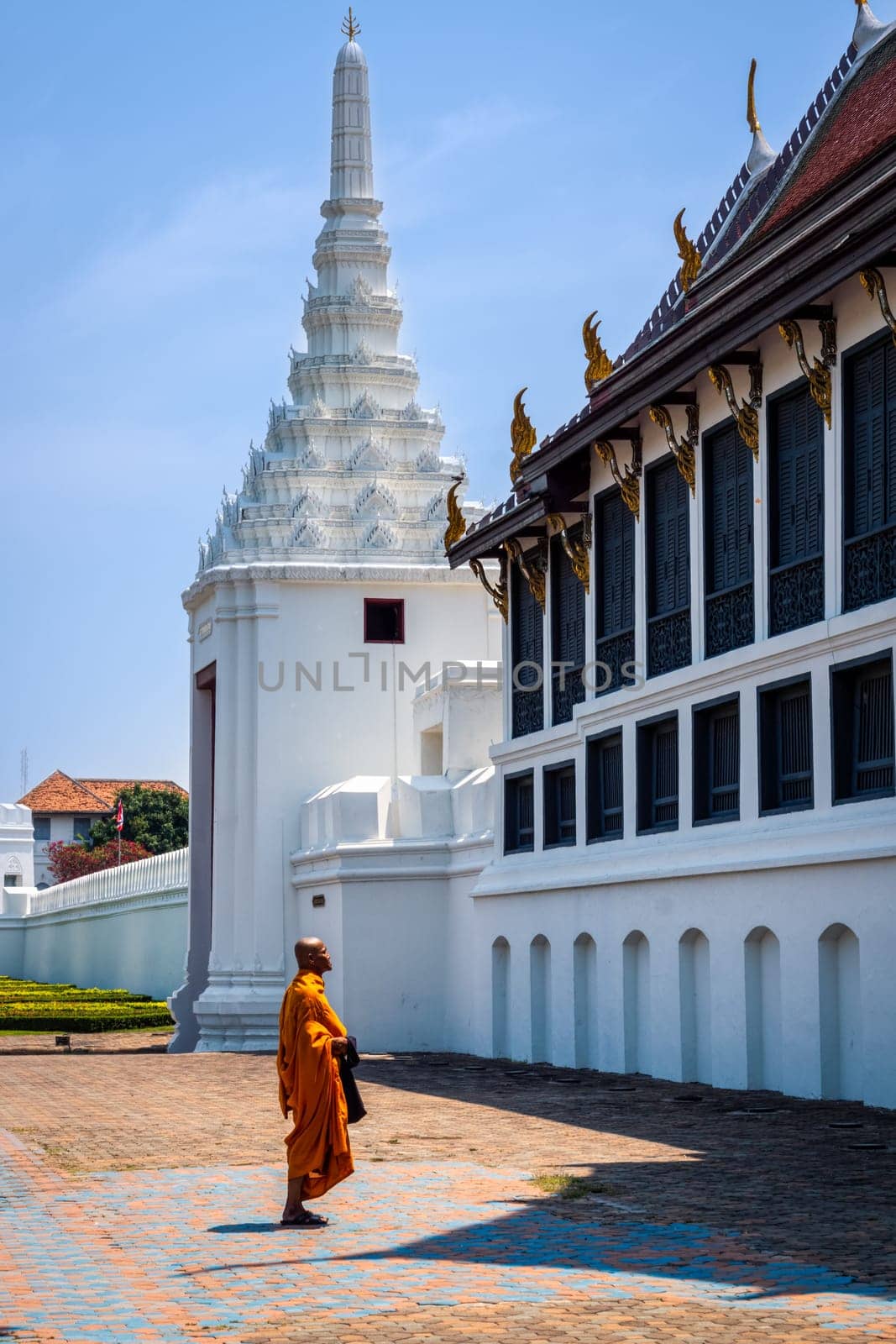 Bangkok, Thailand, March 2013 Single Thai monk praying in front of Grand Palace back balcony