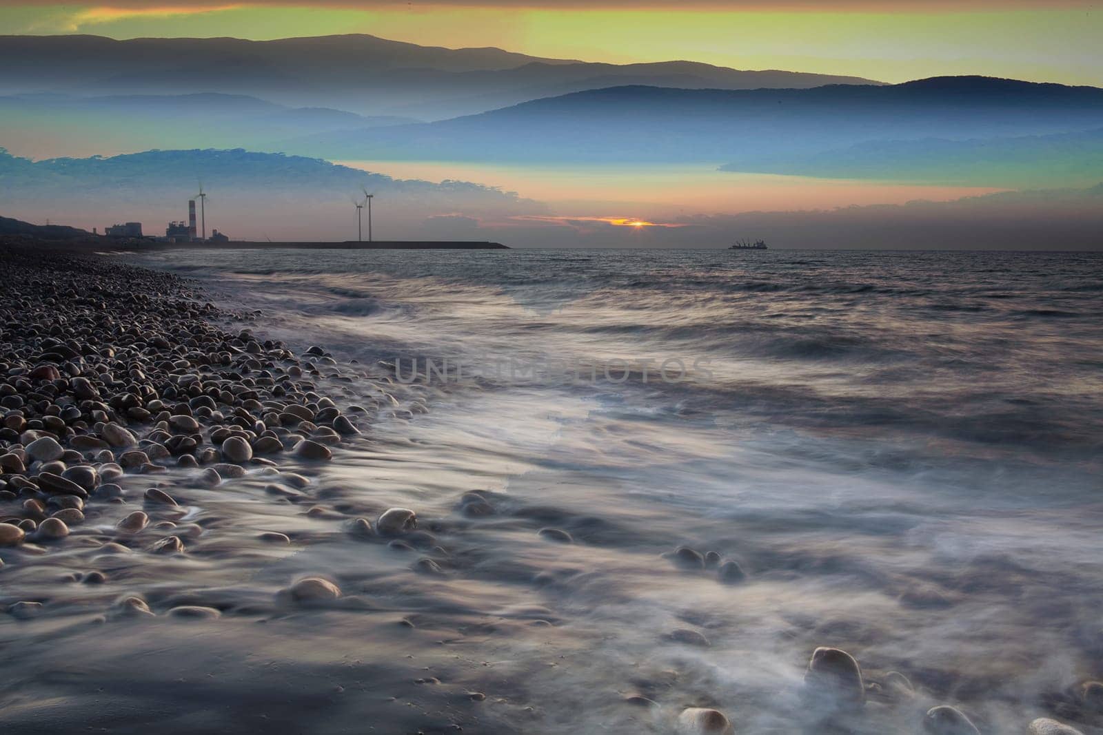The Rocks on stone beach at sunset. Beautiful beach sunset sky. Twilight sea and sky