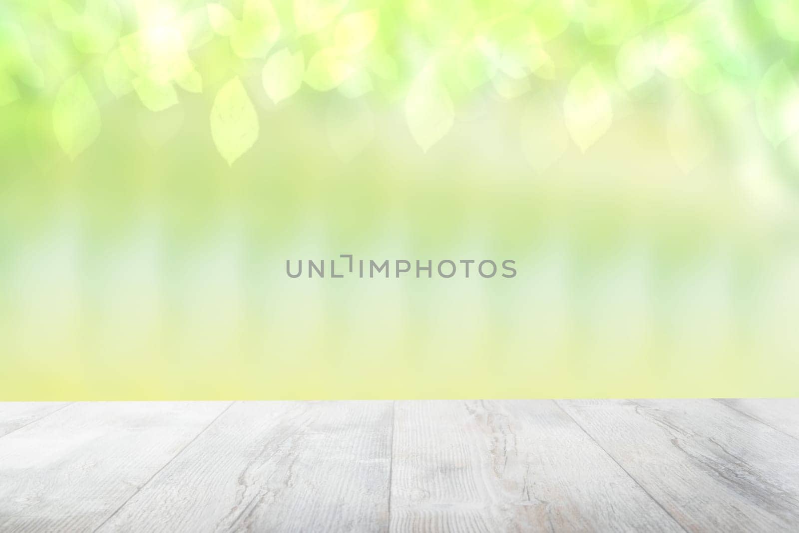 Empty table top summer background. Empty rustic wooden bright table top in front of a beautiful abstract light green spring background. Template for your product display montage.