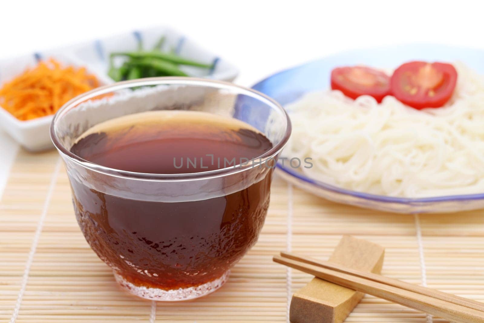 Japanese somen noodles in a glass plate with Mentuyu on white background