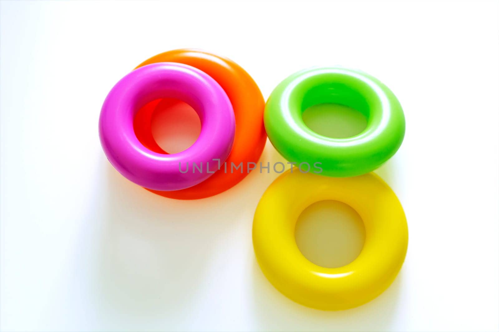 Colorful plastic rings on a white background to be stacked in a tower. Toy for newborns.