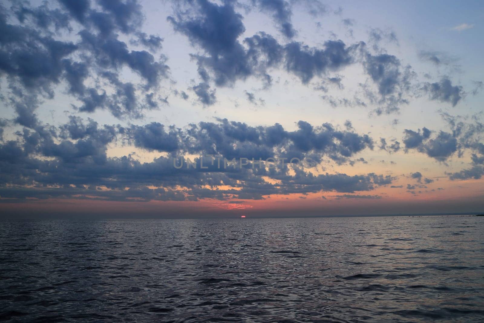 purple sunset dramatic seascape, sun drowned in the sea, panorama