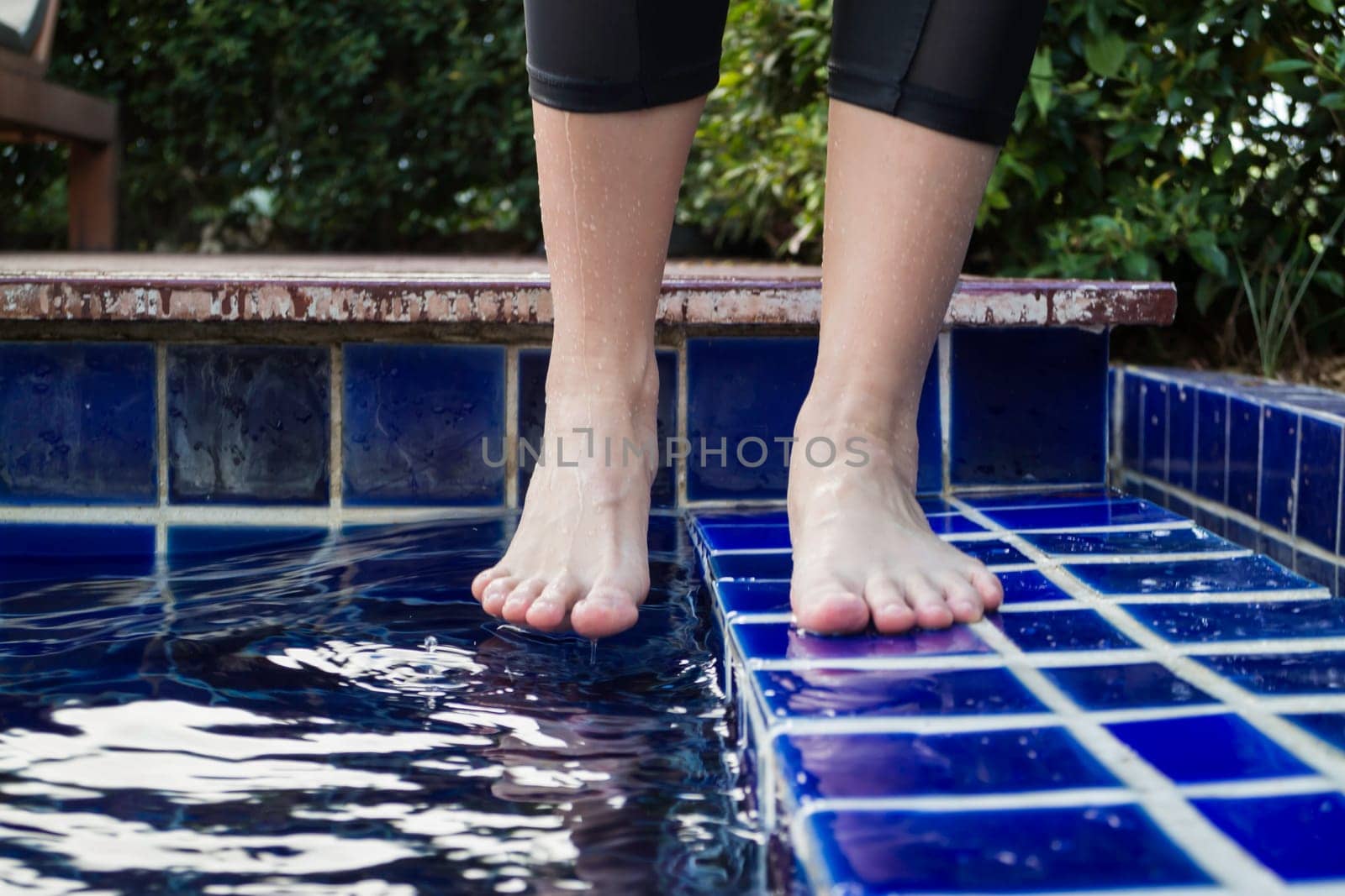Dipping toe in swimming pool, stock photo