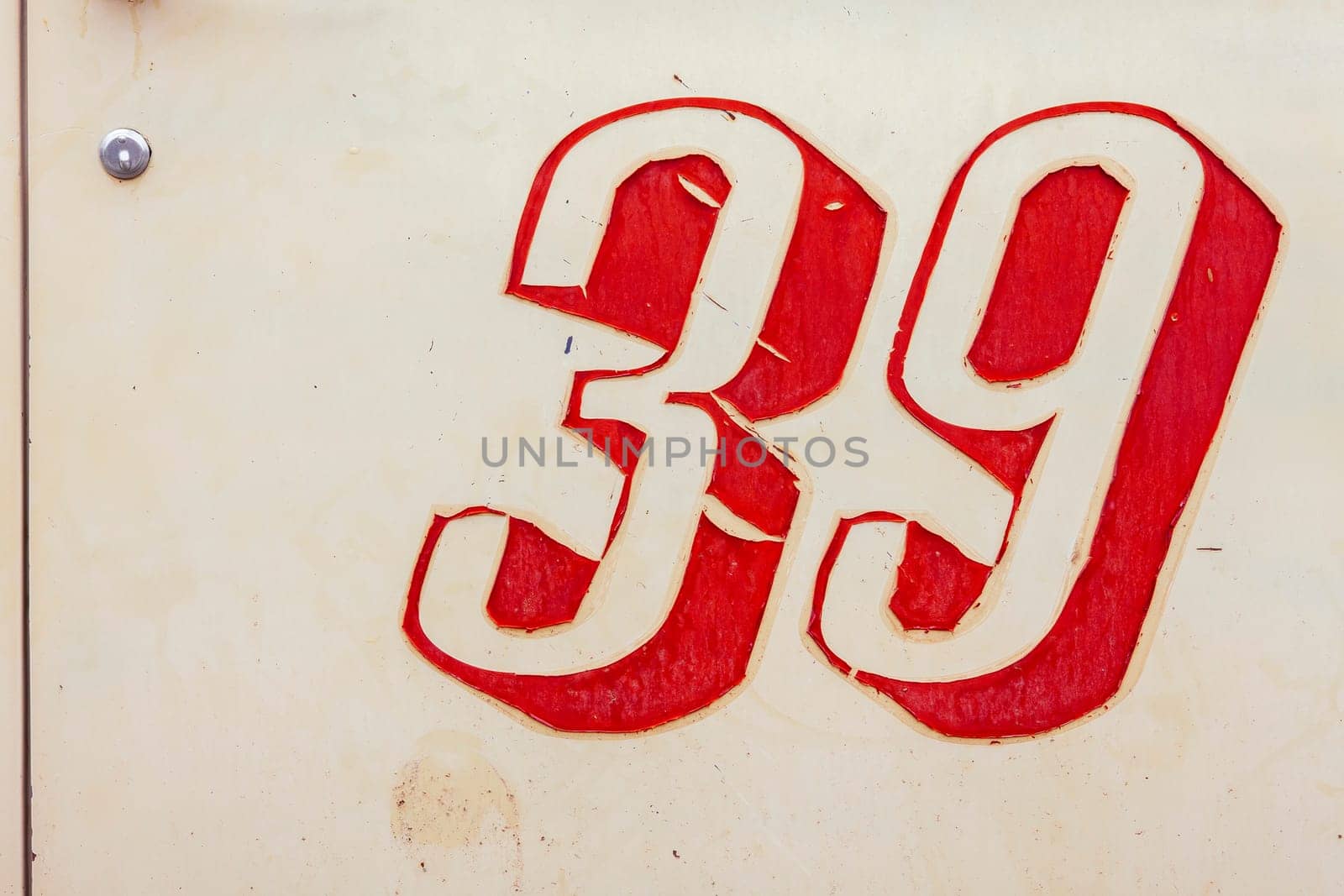 Vintage beige painted metal sign with peeling number thirty-nine decal.