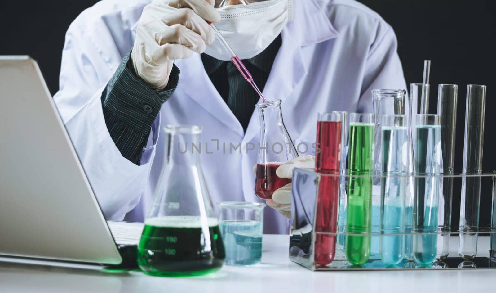 Researcher with glass laboratory chemical test tubes with liquid for analytical , medical, pharmaceutical and scientific research concept.