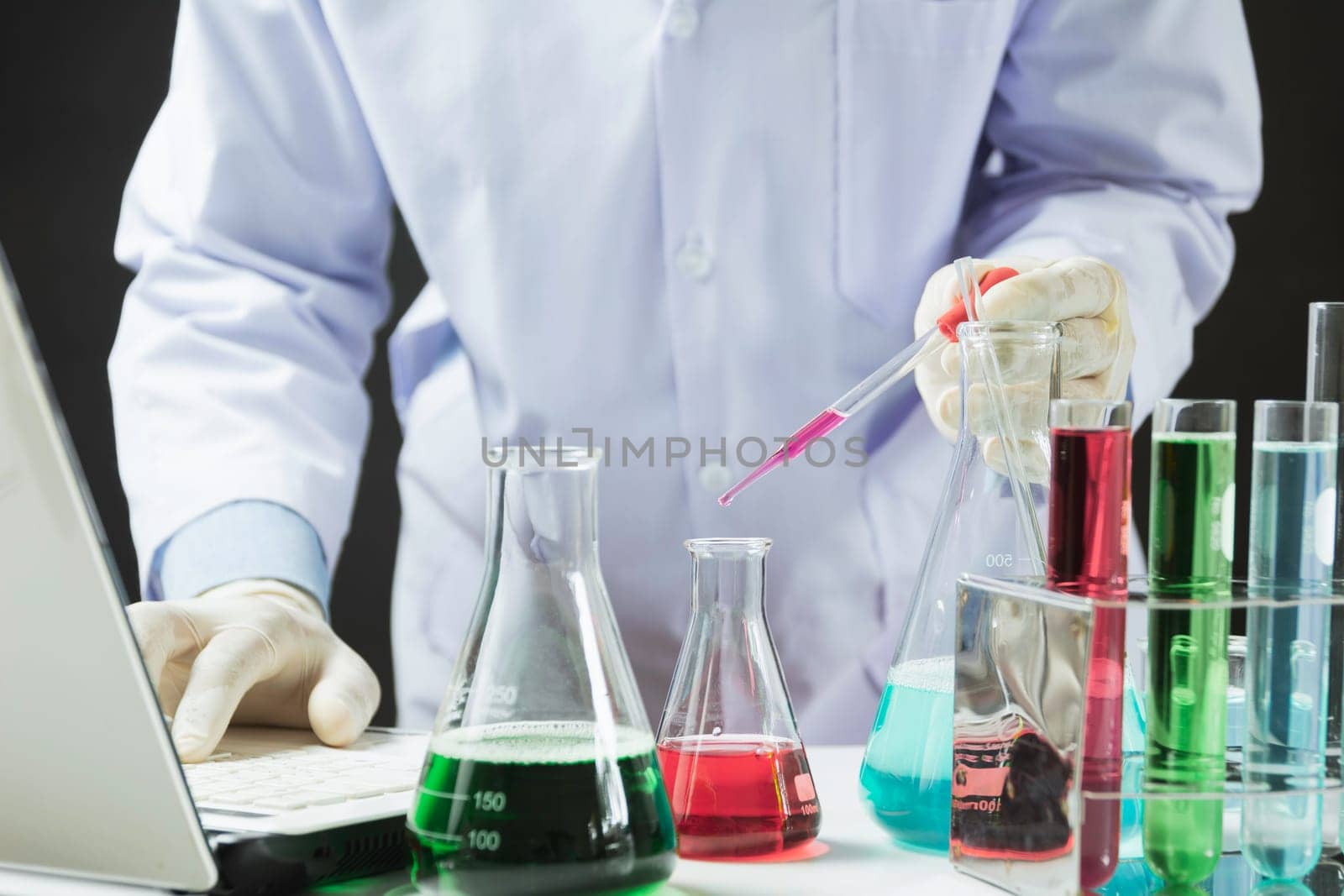 Researcher with glass laboratory chemical test tubes with liquid for analytical , medical, pharmaceutical and scientific research concept.