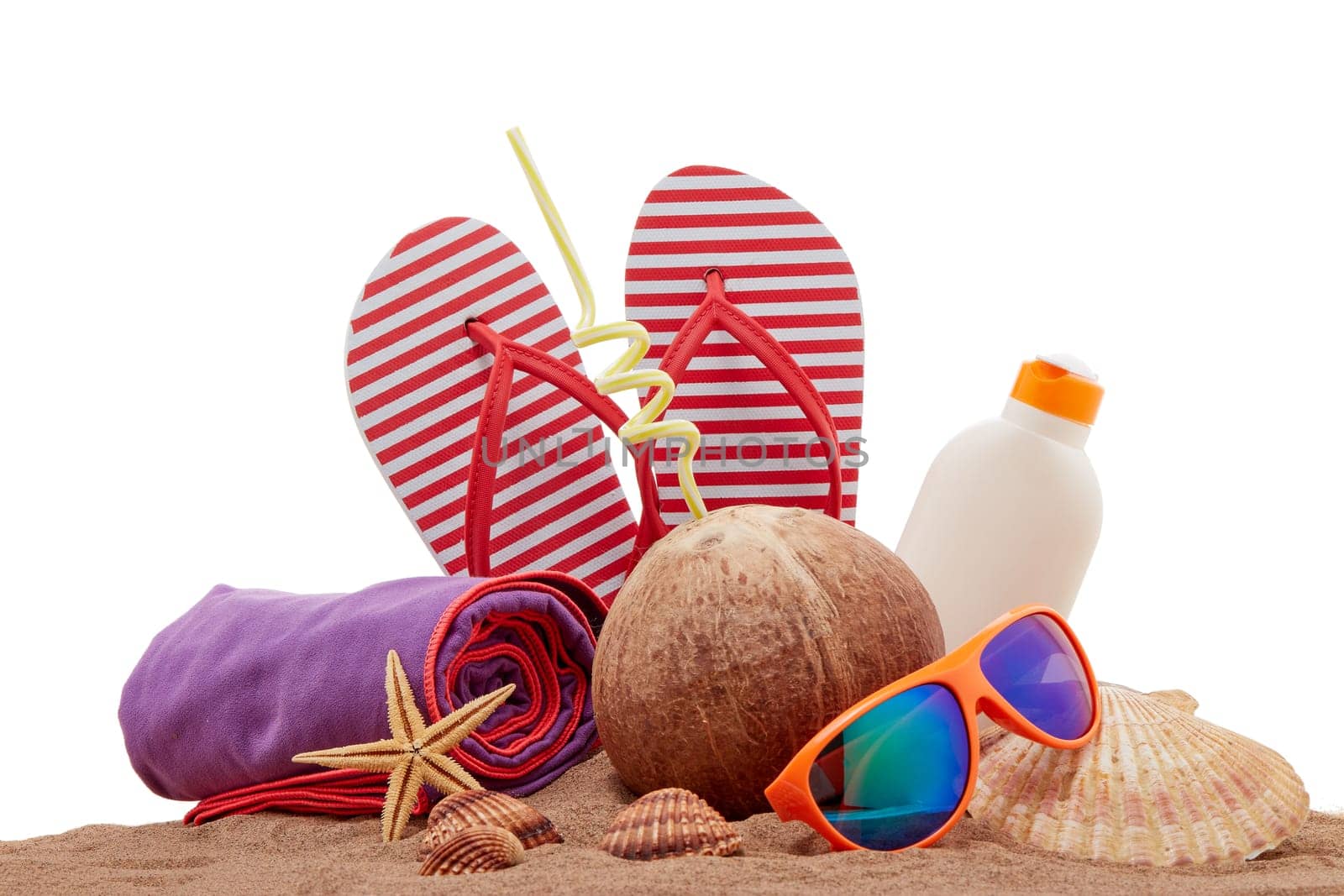 Beach accessories: flip flops, sunglasses, sunscreen, towel, seashells, coconut drink, lying on the sand on white background. Concept of sea vacation and travel. Summer background, Protection from uv