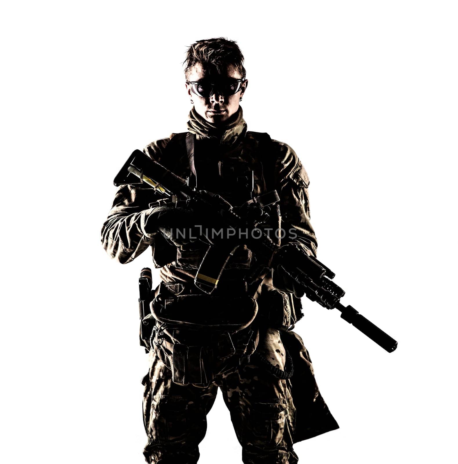 Military company mercenary, army special forces soldier, modern combatant in camouflage battle uniform, ballistic glasses, armed assault rifle with silencer low key studio portrait on white background