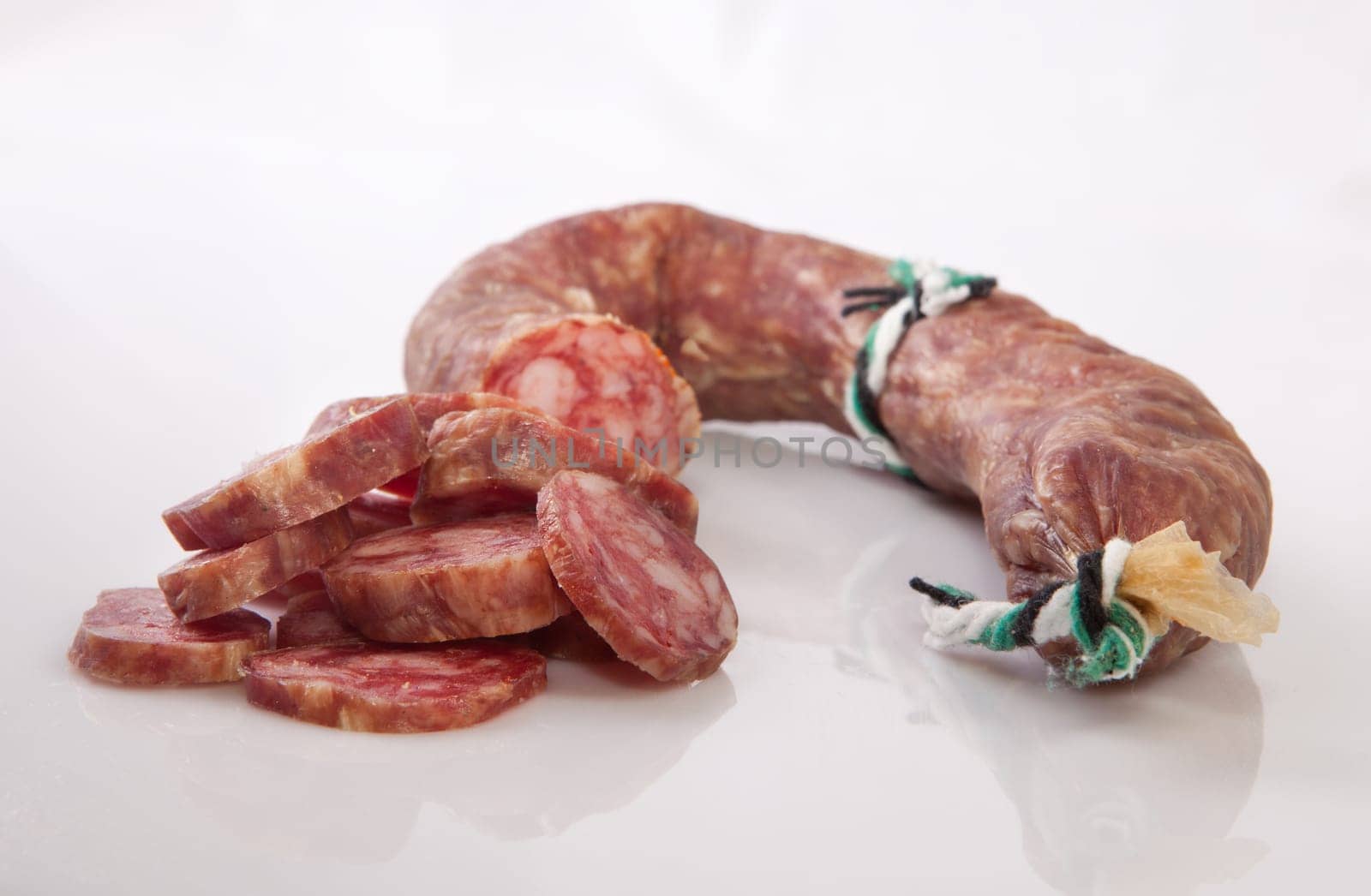 Cured spicy sausage with some cut pieces. Isolated over with background