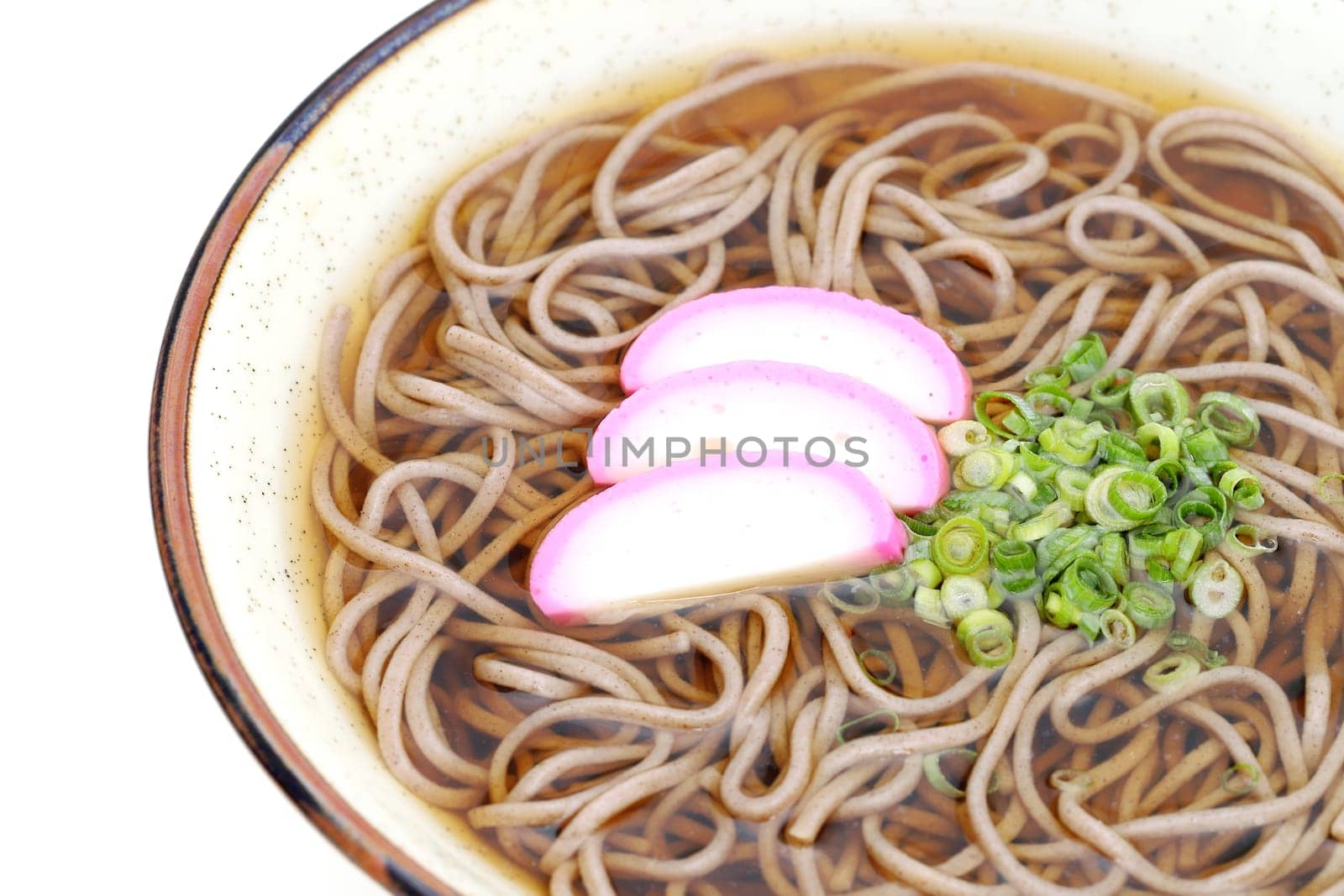 Japanese Kake soba noodles in a ceramic bowl on white background