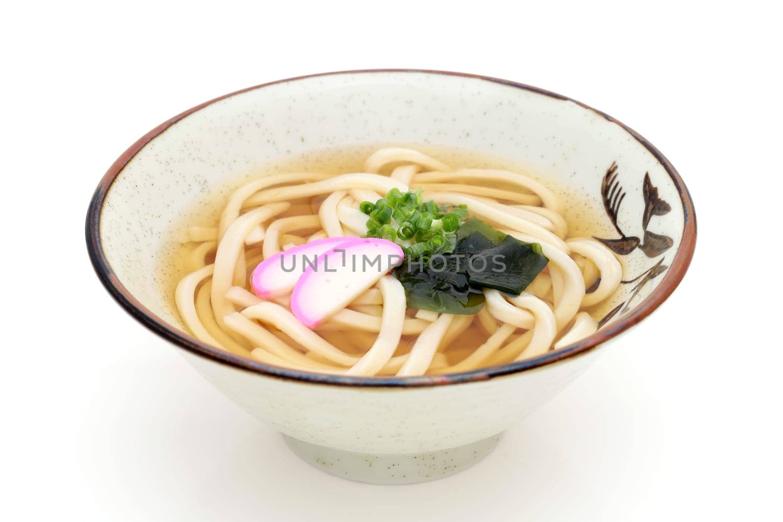 Japanese Kake udon noodles in a ceramic bowl on white background