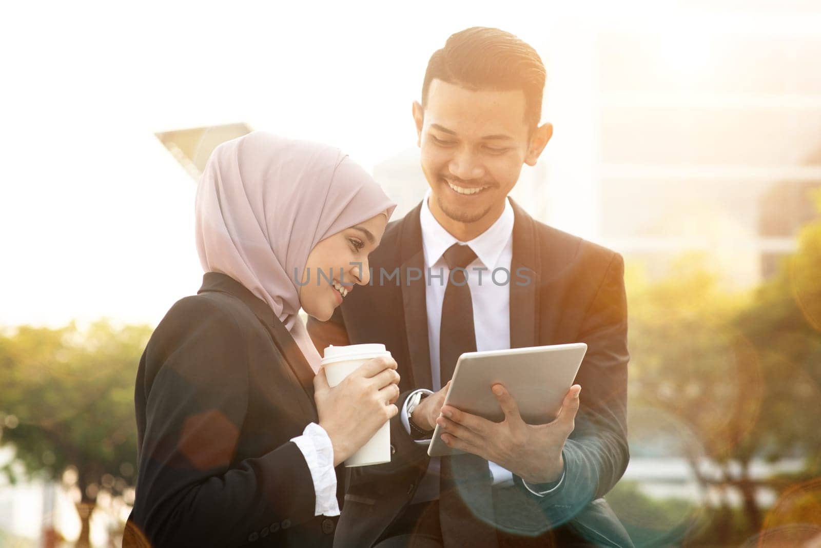 Business team discussing, using tablet pc outside office.