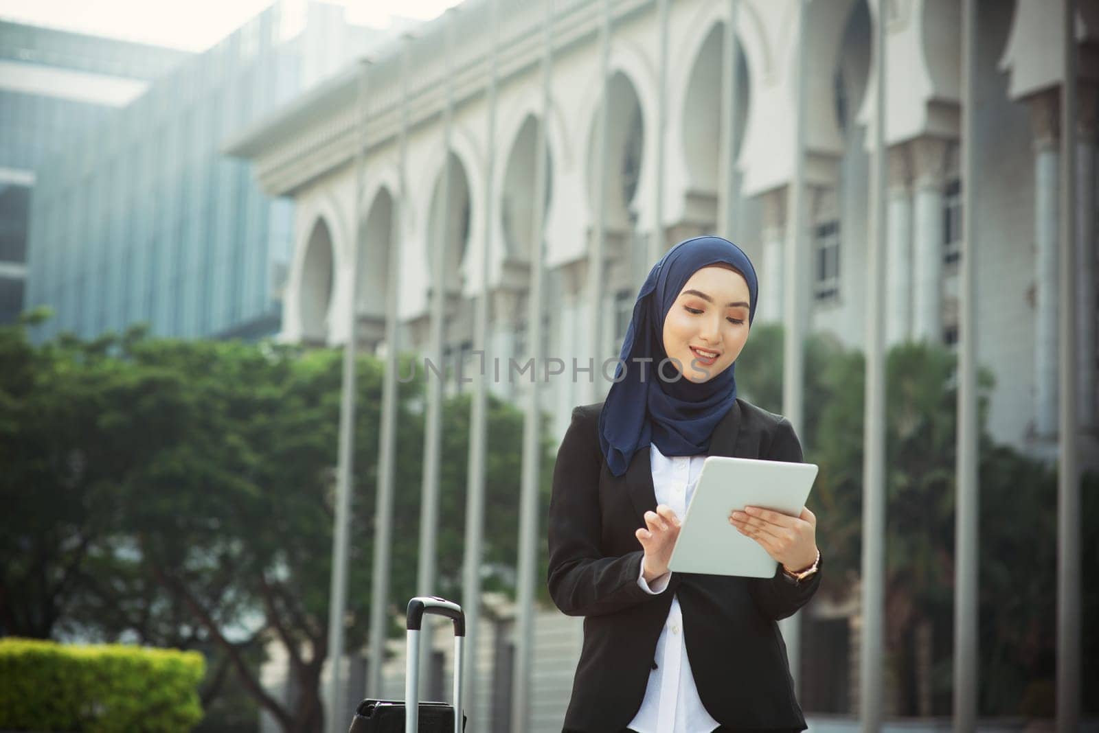 Muslim woman working on table pc outdoor, business travel concept.