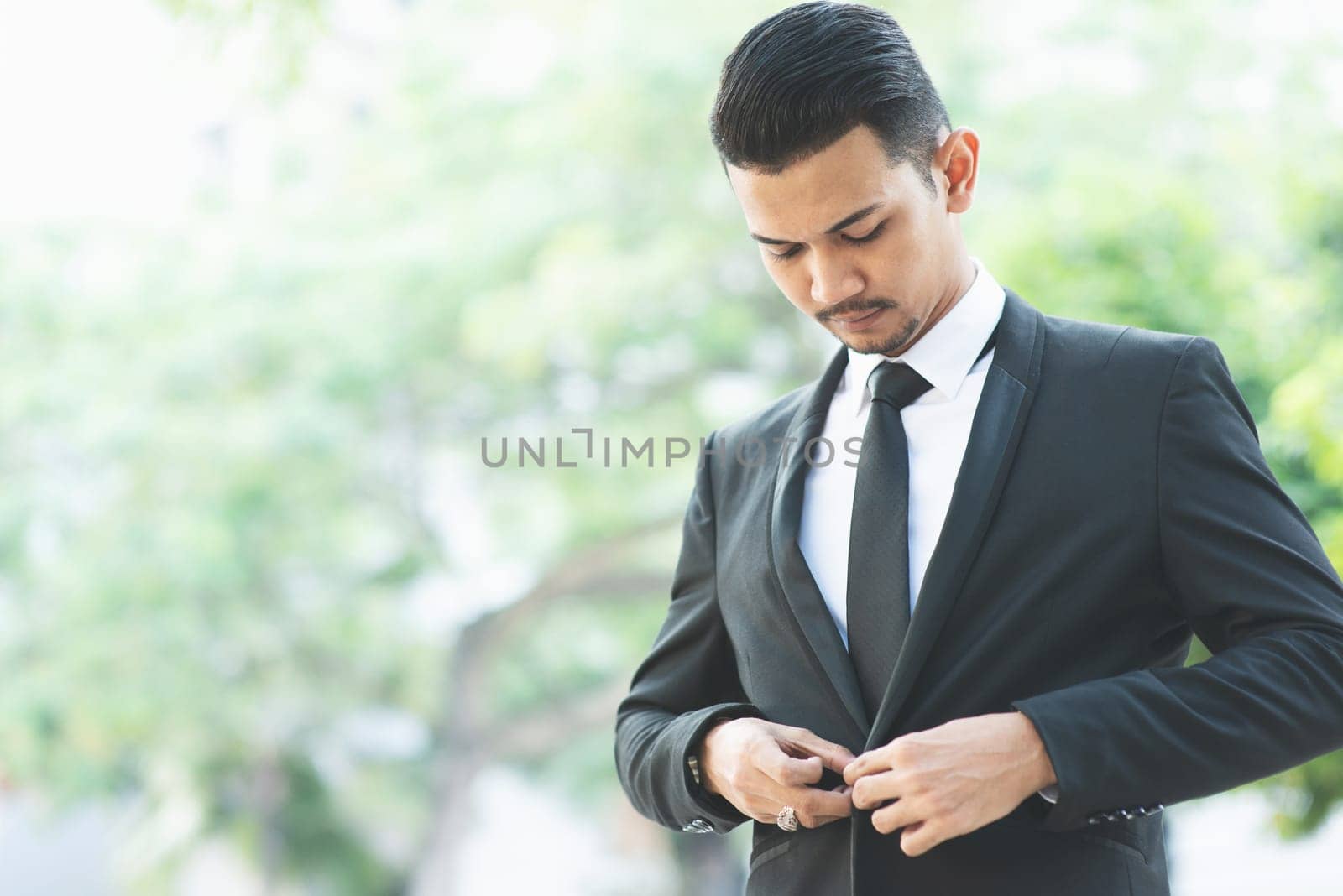 Asian businessman button his suit, get ready for work.